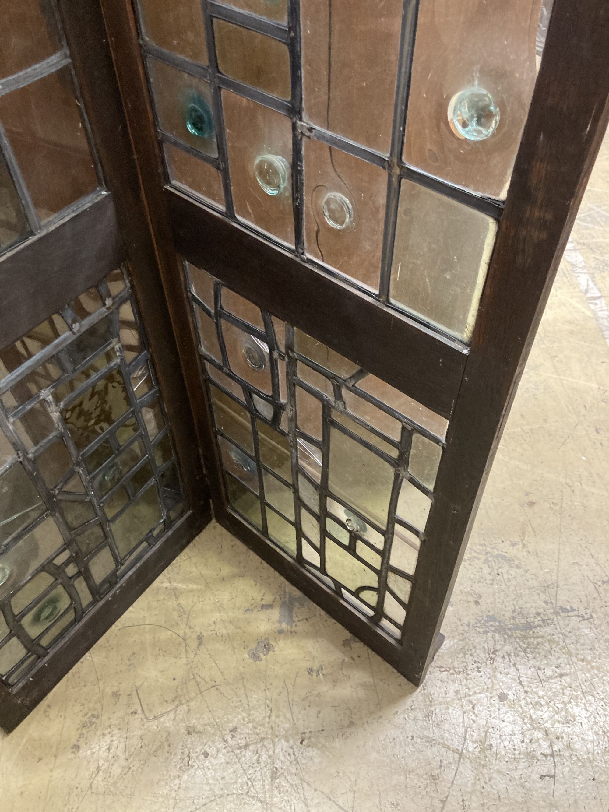 An early 20th century glazed oak two fold screen, each panel width 51cm, height 176cm